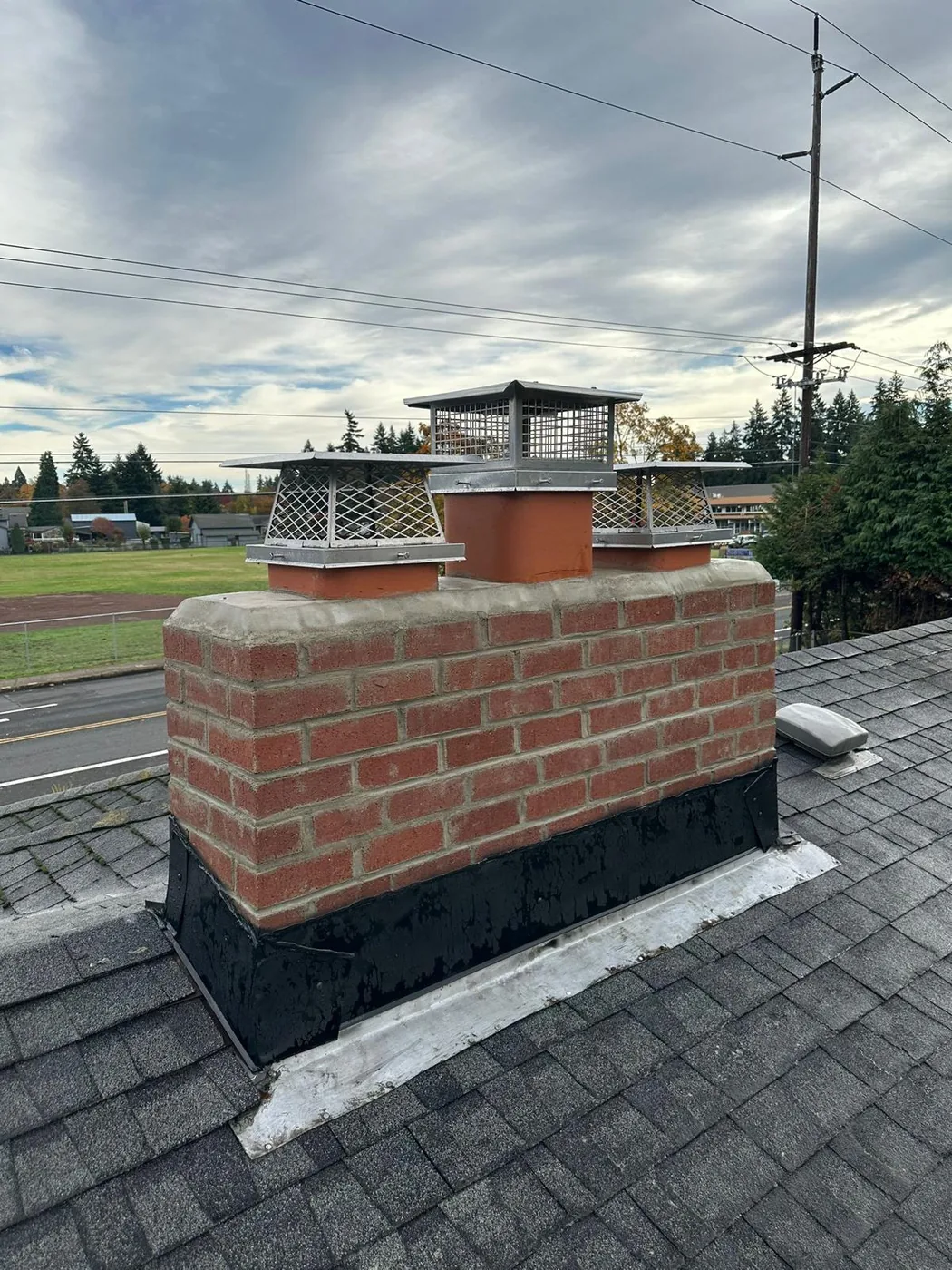 Crumbling Stack & Exposed Flue Tiles → Rebuilt Brick, New Crown & Three New Caps after